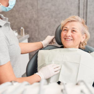 Woman sitting in dental chair and listening to dentist